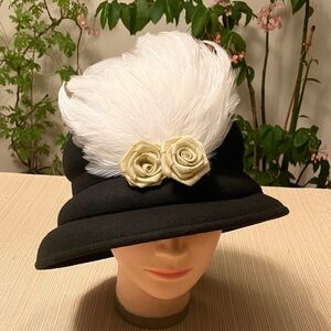 Elegant Black Hat with White Feather and Gold Cream Floral Accents
